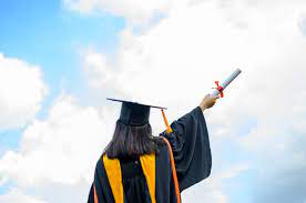 A girl reaching for the sky with a diploma in hand